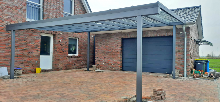 Aluminium-Terrassendach an Backsteinhaus über gepflasterter Einfahrt