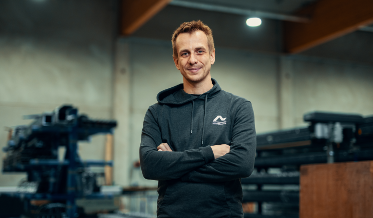 Mann in Werkstatt mit verschränkten Armen