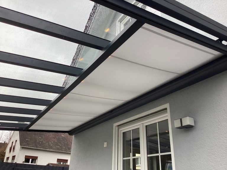 Aluminium-Terrassendach mit diffusen weißen Dachplatten an grauer Hausfassade