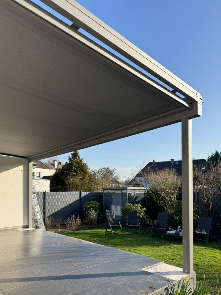 Aluminium-Terrassendach über gefliester Terrasse und Garten