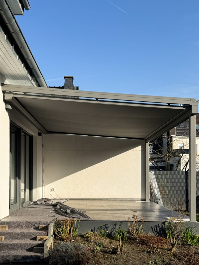 Aluminium-Terrassendach an Hausfassade über Terrasse