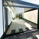 Aluminium-Terrassendach mit Glasschiebewand am Haus